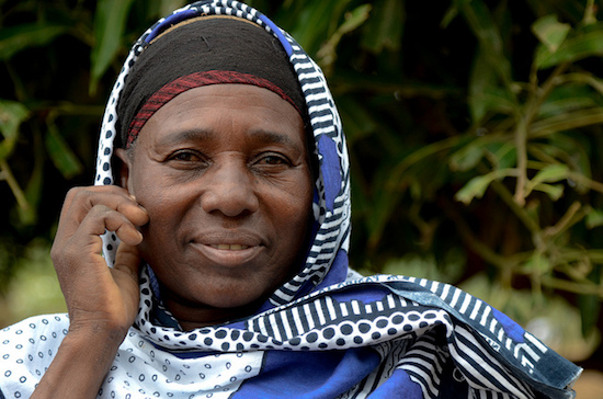 Female beekeeper from Chewele beekeeping Common Interest Group in Kenya looks at camera.