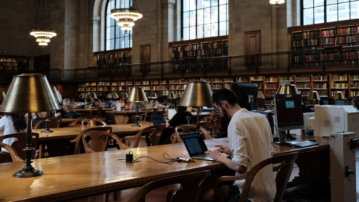 A man using his computer inside a library